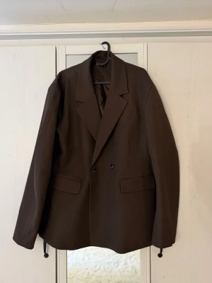 Brun shaped blazer gina tricot - Snygg brun oversized kavaj med dubbelknäppning. Säljer på grund av ingen användning! Knappt använd. 