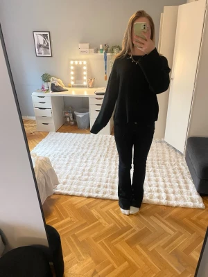 Svart stickad tröja  - En enkel och stilren svart stickad tröja. Tröjan har rund halsringning, långa ärmar och är gjord i ett mjukt material som känns skönt mot huden. Perfekt till jeans eller kjol för en avslappnad look.