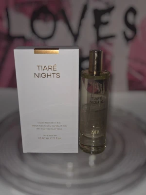 Tiaré Nights parfym från Zara - Tiaré Nights från Zara är en elegant parfym i en genomskinlig glasflaska med gulddetaljer. Doften kommer i en stilren vit förpackning med guldtext. Flaskan rymmer 80 ml och har en modern, minimalistisk design som känns lyxig och trendig.
