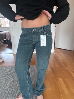 Blå lowwaist straight leg jeans från Zara  - Säljer ett par blå Zara jeans i modellen Liw Rise straight leg. Lågmidjade och trendiga i storlek 38. Jeansen har en avslappnad passform och är tillverkade i denim med lätt tvättad look. Perfekta för en trendig och enkel stil. Helt nya med prislapp på.  Säljer för att de är fel storlek. 