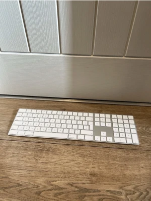 Apple Magic Keyboard a1843 med numerisk del  - Slimmat och stilrent Apple Magic Keyboard med numerisk del. Tangentbordet är vitt med aluminiumram och har låg profil, perfekt för Mac-användare som vill ha en snygg och funktionell lösning till skrivbordet eller även för Windows användare. Trådlöst och laddas upp med iphone kabel. Nyskick!  Nypris runt 1500-2000:-