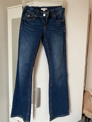 Blå bootcut jeans med slitningar - Säljer tre st  bootcut jeans från Gina Tricot i strl 158.   för 150kr styck. Jeansen har en låg midja och är tillverkade i denim med stretch för skön passform. Perfekta för dig som gillar en avslappnad och trendig look. 