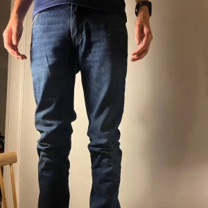 Acne Studios Blå Konst jeans blå - Snygga blå jeans från Acne Studios Blå Konst med klassisk femficksdesign och raka ben. Jeansen har en mörkblå tvätt och subtila kontrastsömmar. Perfekta för dig som gillar stilrena och moderna jeans med en skön passform. Passar någon i längden 175-182 nypris: 1800 kr