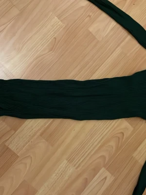 Mörkgrön plisserad långkjol från Mango - Säljer en mörkgrön plisserad långkjol från Mango. Kjolen har en elegant, flowy känsla och är tillverkad i ett lätt, syntetiskt material som ger fina veck. Perfekt för dig som vill ha en stilren och trendig look.