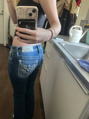 Blå Miss Me jeans  - Säljer ett par blå Miss Me jeans i storlek 25x32 med snygga bakfickor och dekorativa detaljer i silver. Jeansen är bootcut-modell och lågmidjade. Endast provade och är i nyskick. Nypris 2199. Skriv vid frågor💗