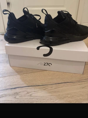 Nike Air Max 270 helsvarta sneakers - Säljer ett par helsvarta Nike Air Max 270 sneakers helt nya har använt max 3 gånger, med klassisk luftig mesh-överdel och stor synlig Air-enhet i hälen. Snygg och sportig design med diskreta detaljer och bekväm passform. Perfekta för dig som gillar stilrena och moderna sneakers.