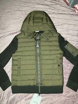 Grön Moncler cardiganjacka med Luva - Olivgrön Moncler cardigan/jacka i storlek L säljes.  Väldigt stilren och exklusiv modell som passar både till vardag och finare tillfällen. Använd få gånger, i mycket fint skick utan slitage.     Scan och Kvitto Finns