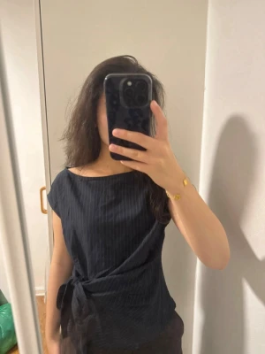 Randig mörkgrå blus knytning Cider - Randig mörkgrå blus med knytning på sidan från Cider Materialet är som kostym ungefär Ränderna är lite punkterade (se sista bilden) Använd 2 gånger så toppenskick💞💞