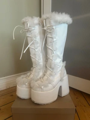 White boots - Vita fluffiga knähöga Demonia Camel 311 boots 🤍🤍🤍  Använd undersida men i jättebra skick! 🪽 