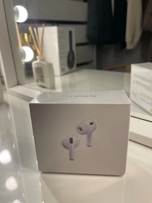 Apple AirPods Pro trådlösa hörlurar - Säljer ett par Apple AirPods Pro i vitt. De är true wireless in-ear hörlurar med stilren design och silikonproppar för bra passform. Perfekta för dig som vill ha grymt ljud och smidig anslutning till din iPhone eller andra Apple-enheter. Oöppnade