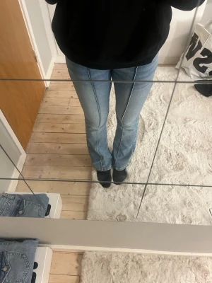 Blå bootcut jeans från Lindex - Snygga ljusblå bootcut jeans från Lindex med markerade sömmar längs benen och coola fickdetaljer bak med silverknappar. Jeansen har normal passform. Det är storlek 170 men passar mig som brukar ha storlek 36 