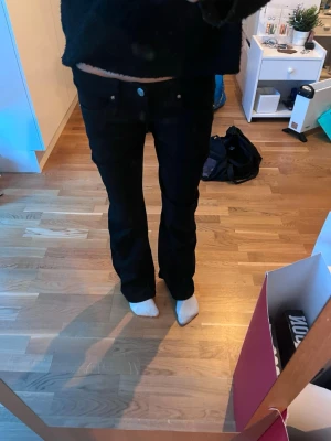 Svarta bootcut jeans - Säljer ett par svarta bootcut jeans meklassisk femficksdesign. Jeansen har en snygg passform som sitter tajt över låren och släpper ut vid vaden. Perfekta till sneakers eller boots och passar till många olika stilar💛💛
