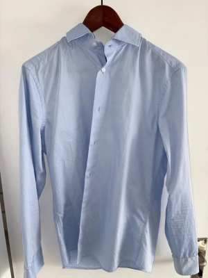 Riley slim fit skjorta herr  - Tjaba, säljer denna ljusblåa herr skjorta från Riley. Stilren skjorta i hög kvalité, fortfarande i perfekt skick! Nypris 1200. Används inte längre pga den är för liten! Priset är såklart diskuterbart! 