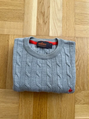 Morris Tröja i Merinoull - En stilren grå kabelstickad tröja ifrån Morris i storlek XS. Till skillnad från de flesta tröjor som säljs här så är denna inte krympt och sitter enligt storleken. Tröjan har knappast använts och är i dunder skick. Vid frågor eller funderingar är det bara att höra av sig! 😁.