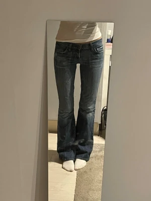 Blå lågmidjade bootcut jeans - Jättefina vintage jeans som jag köpt begagnat Innerbenslängd: 82cm.                             Midjemått: 35cm                                              Grenhöjd: 18cm