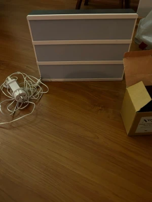 Ljusskylt med vit ram och grå panel - Säljer en ljusskylt med vit ram och tre grå paneler. Skylten är rektangulär och har en sladd med stickkontakt för el. Perfekt för att skriva egna meddelanden eller citat. Passar bra som dekoration i rum eller på event.