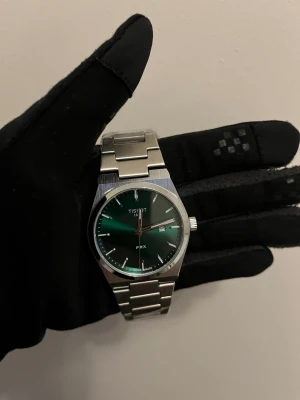 Tissot Klocka  - Tjena, säljer denna tvär snygga tissot klockan med grön bakgrunds färg. Klockan är helt ny och oanvänd. Har även extra länkar som kan skickas med. Passar perfekt med allt. Skriv gärna vid intresse! 