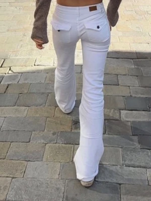 Vita bootcut jeans med fickdetaljer Nelly  - Säljer ett par vita bootcut jeans med snygga fickdetaljer bak. Jeansen har låg midja och är i stretchigt material för skön passform. Perfekta för dig som vill ha en clean och trendig look. Jenasen är från Nelly. Nypris 700kr.  Skriv frågor och skicka prisförslag så svarar jag så fort jag kan 