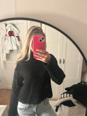 Svart stickad polotröja - Mysig svart stickad polotröja med lång ärm och avslappnad passform. Tröjan har en hög krage och är perfekt för kalla dagar. Passar till både jeans och kjol för en enkel och snygg look. Är från Gina barn men sitte bra på mig som är 165