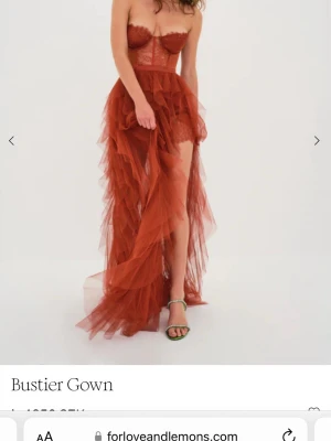 Bustierklänning från For Love & Lemons - En supersnygg balklänning från For Love & Lemons. Klänningen har en slits framtill och en insydd body med spetsdetaljer. Storlek XS men lång på längden.