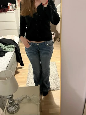 Blå bootcut jeans från True religion  - Säljer ett par blå bootcut jeans från true religion med låg midja och klassiska fem fickor. Jättefint skick!!