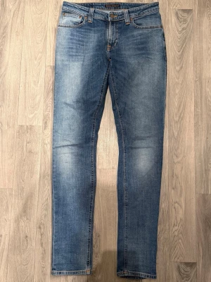 Nudie Jeans Blå W29 L34 - Mycket fint skick. Storlek W29/L34. Mått - Midja: 39,5cm, Ytterbenslängd: 107,5cm, Benöppning: 15cm. Modellen är 185cm & 63kg. Hör av dig vid funderingar!🤝