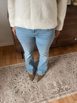 Ljusblå bootcut jeans från 157 - Snygga ljusblå jeans från 157 med klassisk femficksmodell och bootcut-ben. Jeansen har normal midja och är tillverkade i mjuk denim med lite stretch för extra komfort. Perfekta för en avslappnad och trendig look.