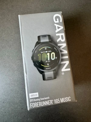 Garmin Forerunner 165 Music Smartklocka - Säljer en Garmin Forerunner 165 Music smartklocka med AMOLED-skärm och GPS. Klockan är svart med rund urtavla och silikonarmband. Perfekt för löpning och musik direkt på handleden. Modern design och tydlig display. Nypris 3490 kronor.