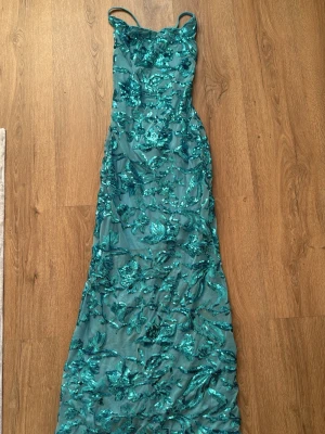 Turkos Paljettlångklänning med Korsad Rygg  - Stl S , bara testad men den var för liten för mig! 