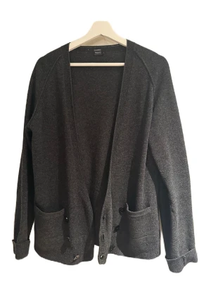 Filippa K cardigan - En fet cardigan från Filippa K i färgen grå och storleken S. Skick 7/10 den är lite äldre så några små skavanker finns men annars helt fel fri. Kom dm för fler frågor osv!