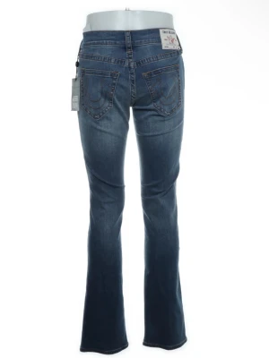 True religion bootcut jeans - Snygga blå True Religion bootcut jeans. Stretchiga och har en lätt tvättad look och markerade bakfickor med dekorativa sömmar. Använda en gång!