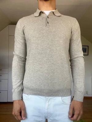 Beige stickad tröja med krage - Beige stickad tröja med krage från bläck. Tillverkad i 100% bomull. Strl S. Inga defekter. Modellen är 178 cm och väger 77 kg. Hör gärna av dig vid frågor!