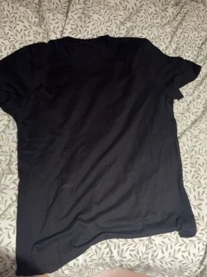 Svart basic t-shirt - En enkel svart t-shirt med rund hals och korta ärmar. Perfekt till jeans eller shorts och funkar året runt. Tillverkad i mjukt material som känns skönt mot huden.