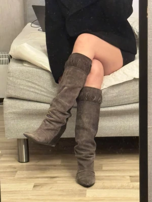 Bruna knähöga mockastövlar med kilklack - Säljer ett par otroligt snygga stövlar från Isabel Marant! Detta är en sällsynt, utgången modell från märkets arkiv som inte längre går att få tag på i butik. ✨ Detaljer:  Märkets ikoniska inbyggda kilklack – supersköna att gå i och ger en fantastisk silhuett.  Lyxig mix av mocka framtill och slätt skinn baktill. ✨ Storlek: 37 ✨ Skick: Fint använt skick! De är sparsamt använda av mig och den tidigare ägaren. Det finns normala spår av användning, stör dock inte utseendet eller funktionen.