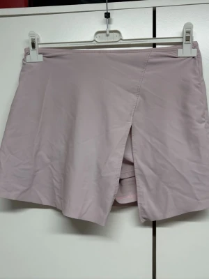 Badshorts/badkjol  med slits framtill - Badshorts /badkjol  med en stilren slits framtill. Kjoldesign med inbyggda shorts under för extra komfort och rörelsefrihet. Tillverkad i ett mjukt och lätt material som känns skönt mot huden. Perfekt för dig som vill ha både stil och funktion när du badar