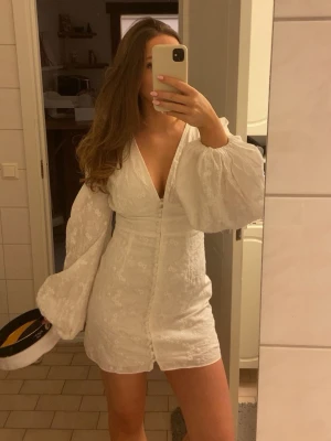 Vit klänning från Adoore  - Intressekoll på min fina klänning från adoore. Använd ca 3 gånger och är i väldigt fint skick!💕den har blivit lite missfärgad ( brun utan sol ) på vissa sömmar på insidan av klänningen, men inget som man tänker på 