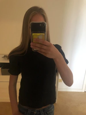 Svart topp med puffärmar - Snygg svart topp med puffärmar och rund hals. T-shirten har en enkel men trendig design som passar perfekt till jeans eller kjol.💕