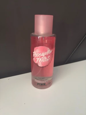 Rosewater Mist body mist från PINK - Fräsch och blommig body mist med doft av rosenvatten, litchi och kokosvatten. Flaskan är cylindrisk och genomskinlig med rosa etikett och lock. Perfekt för dig som gillar lätta och fräscha dofter med inslag av ros och exotiska toner. Det är 4/5 kvar i flaskan och den är discontinued. Pris kan diskuteras 