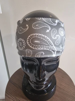 Bandanas/hårband grå - Bandanas/hårband cashewnöt. Elastisk. 50 cm huvud. Trikåtyg. Elastisk. Andningsbar. Rynkfri. Polyester.