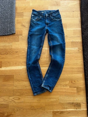 Mörkblå skinny jeans - Snygga mörkblå skinny jeans med klassisk femficksdesign och smal passform. Jeansen har normal midja och är tillverkade i stretchigt denimtyg för extra komfort. Perfekta till en avslappnad streetstyle-look.