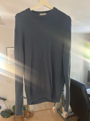 Blå stickad tröja från MNG - Snygg blå stickad tröja från MNG i storlek L. Tillverkad av italienskt garn med rund halsringning och ribbade muddar vid ärmslut och nederkant. Enkel och stilren design som passad till allt och även är trendig.