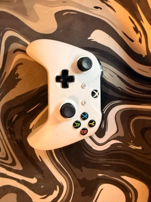 Vit Xbox-handkontroll ( 2 i lager men säljer en för 400kr ) - Säljer en vit Xbox-handkontroll med klassisk layout, två analoga spakar, styrkors och färgade knappar. Handkontrollen har en stilren design och är tillverkad i plast. Perfekt för gaming på Xbox eller PC.