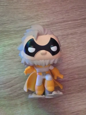 Superhjälte cosplay-figur med mask - Cool cosplay-accessoar i form av en superhjältefigur med svart mask, vit och gul dräkt samt cape. Perfekt som dekoration eller till maskerad och cosplay. Figuren har detaljerat hår och skägg i grått och står på en bas.