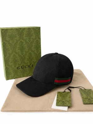 G.U.C.C.i Keps - Exklusiv G.U.C.C.I keps i stilren svart design 🖤 Aldrig använd – i nyskick och levereras med originalbox, dustbag och tags 🎁 Den ikoniska gröna och röda Web-detaljen ger kepsen en exklusiv och tidlös look, perfekt till både vardag och finare outfits ✨  🔹 Märke: G.U.C.C.I 🔹 Färg: Svart 🔹 Detaljer: Ton-i-ton GG Monogram & klassisk Web-rand 🔹 Skick: Oanvänd 🔹 Tillbehör: Originalbox, dustbag & tags  En ikonisk keps för dig som uppskattar lyx, kvalitet och tidlös design 💎 Redo att användas