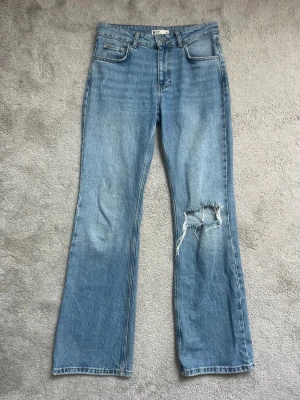 Jeans med revor  - Flare jeans från Gina tricot med revor. Har en svag fläck. Midjemåttet tvärs över är 37,5 cm. 