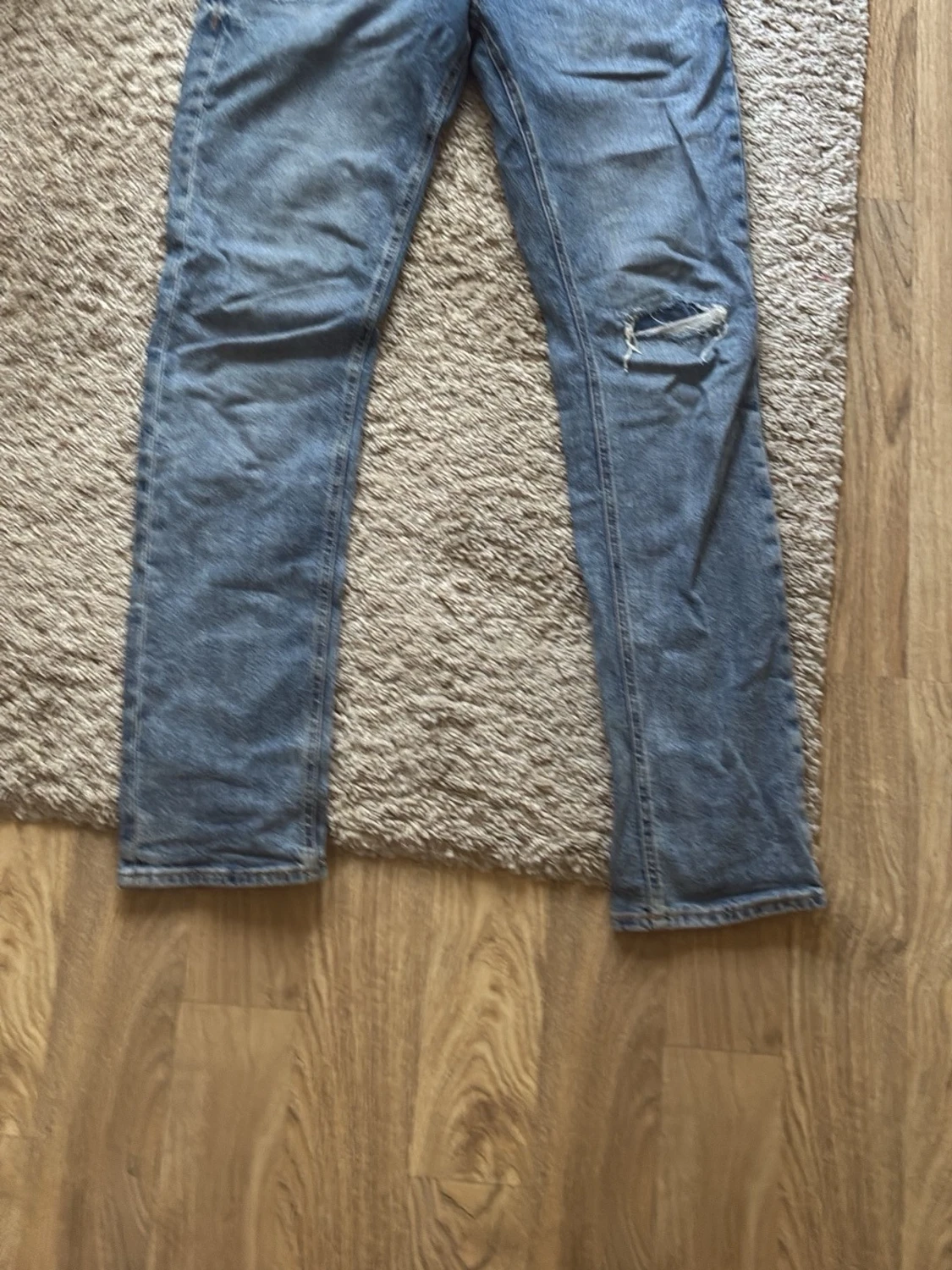 Blå raka jeans med slitning