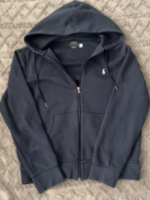 Mörkblå hoodie från Polo Ralph Lauren - Sjukt snygg hoodie från Ralph lauren. Har blivit lite solblekt men inte mycket alls fortfarande en jätte fin tröja.