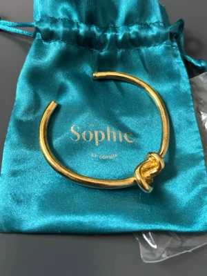 Sophie by Sophie Knot Cuff-armband, guld - Populärt cuff armband från SOPHIE by SOPHIE. Armbandet är tillverkat i 925 sterling silver med en 18K guldplätering. Kan försiktigt formas om för att passa just din handled.  Nypris ca 5000 kr. 