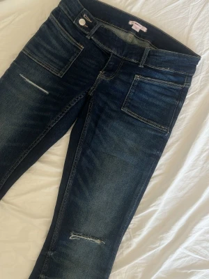 Virala Mmörkblå bootcut jeans med slitningar - Säljer ett par mörkblå bootcut jeans med hål  på låren.  Dom är är lite slitna längst ner men detta syns inte. Skriv för fler bilder eller annat💗