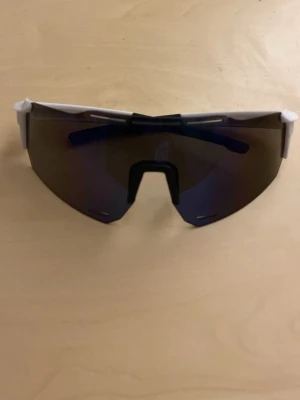 Sportglasögon - Säljer ett par sportiga solglasögon. De har en futuristisk, kantig design och passar perfekt för dig som gillar en aktiv livsstil. Snygga att bära till både träning och chill.